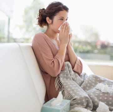 sick woman blowing her nose