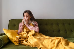 vrouw zit ziek op de bank