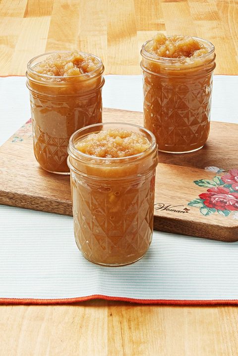 homemade applesauce in jars with cutting board