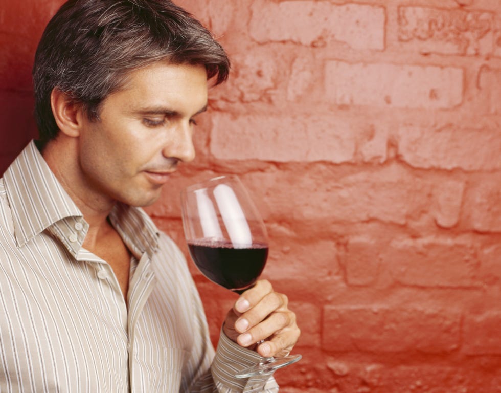 side profile of a mid adult man drinking red wine