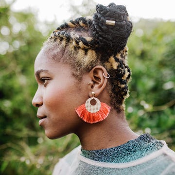 side profile of beautiful young woman with green foliage background