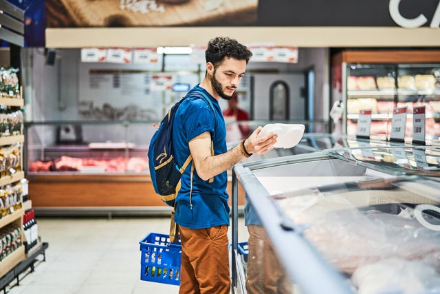 side view of customer buying packed food at supermarket