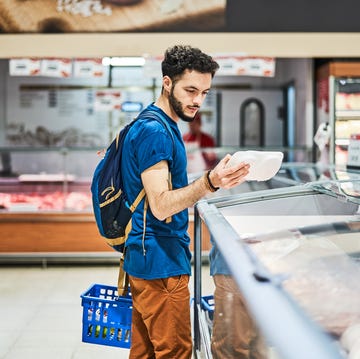 side view of customer buying packed food at supermarket