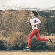 side view of female athlete running by field