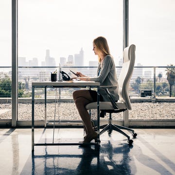 side view of female entrepreneur sitting at desk working in office