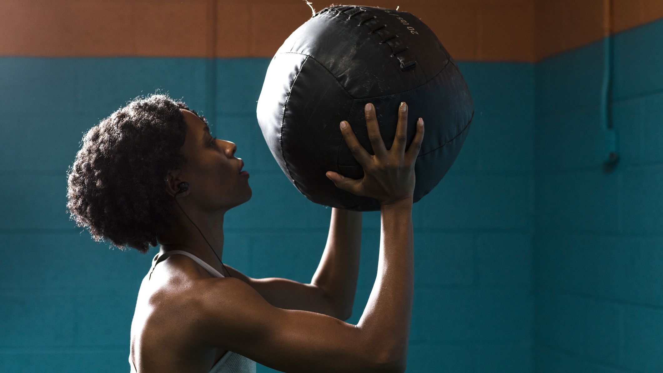 https://hips.hearstapps.com/hmg-prod/images/side-view-of-woman-holding-medicine-ball-while-royalty-free-image-1689786365.jpg?crop=1xw:0.84415xh;center,top