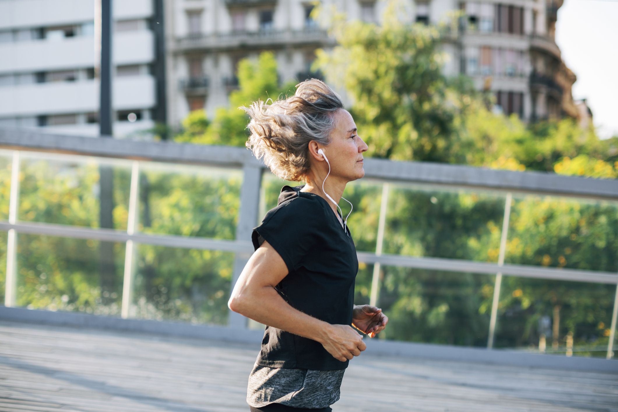 https://hips.hearstapps.com/hmg-prod/images/side-view-of-woman-jogging-while-listening-music-at-royalty-free-image-1571950133.jpg