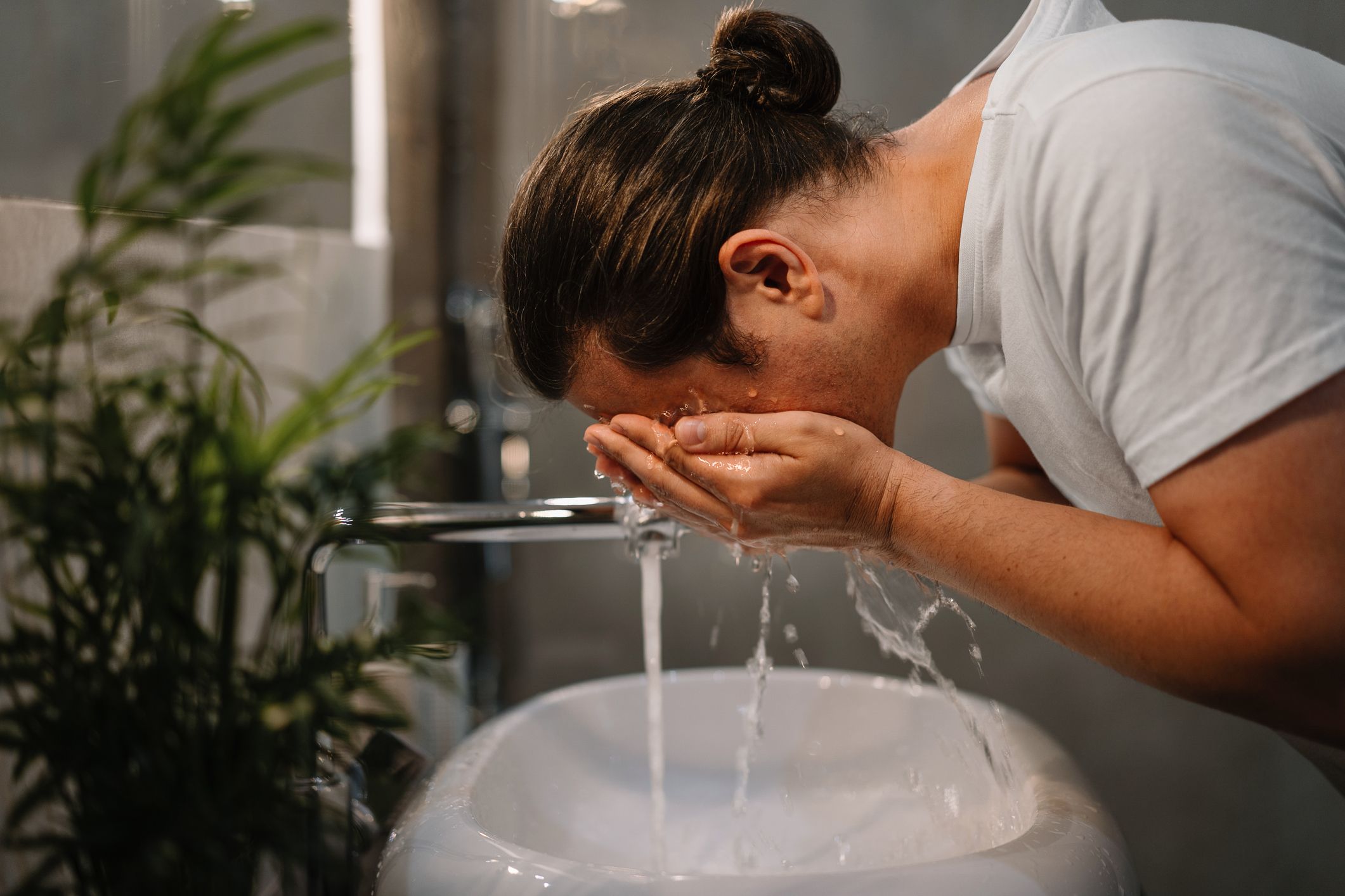 https://hips.hearstapps.com/hmg-prod/images/side-view-of-young-man-washing-his-face-in-bathroom-royalty-free-image-1655904012.jpg