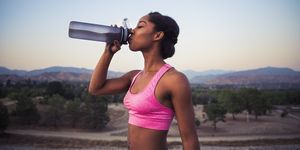 Side view of young woman drinking from water bottle