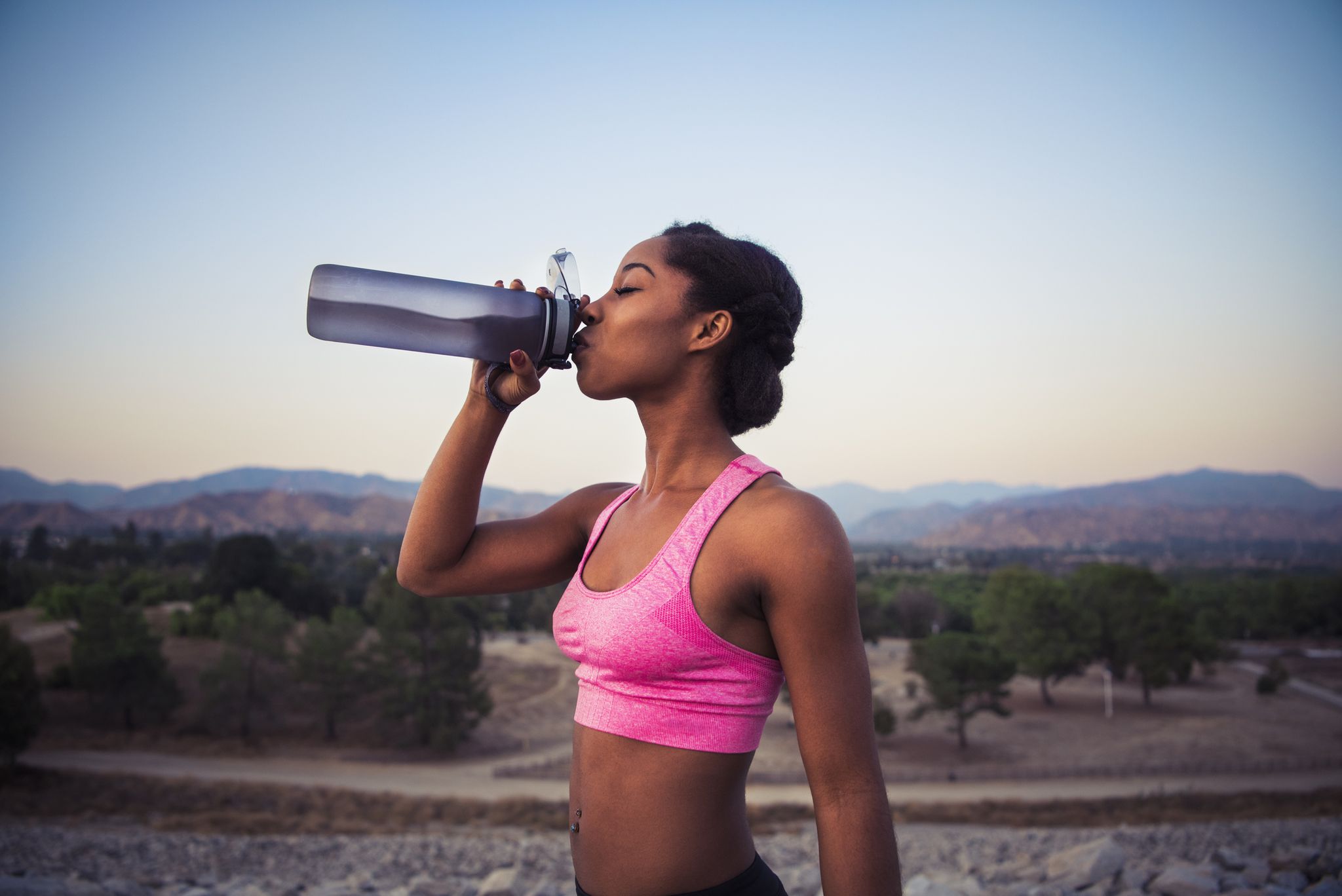 Side view of young woman drinking from water bottle