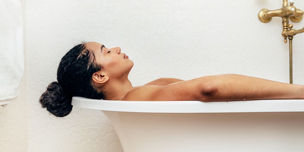 side view of young woman having a bath