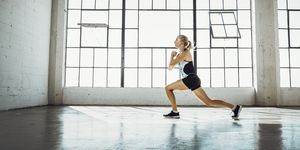 woman doing jumping lunges in the gym