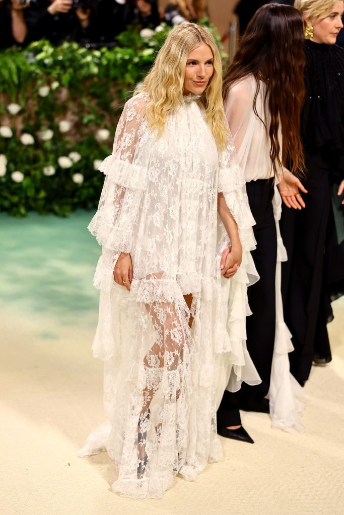 sienna miller attends the 2024 met gala in a white lace dress