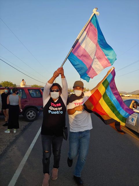 bautista waving the trans flag at a covid 19 safe car rally on april 10th outside of two arizona detention centers in a coalition called azfreethemall, activists were calling for ice and arizona governor ducey to freethemall from detention, and end all ice enforcement and deportation operations