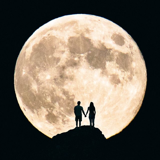 Silhouette Couple Holding Hands Against Moon At Night