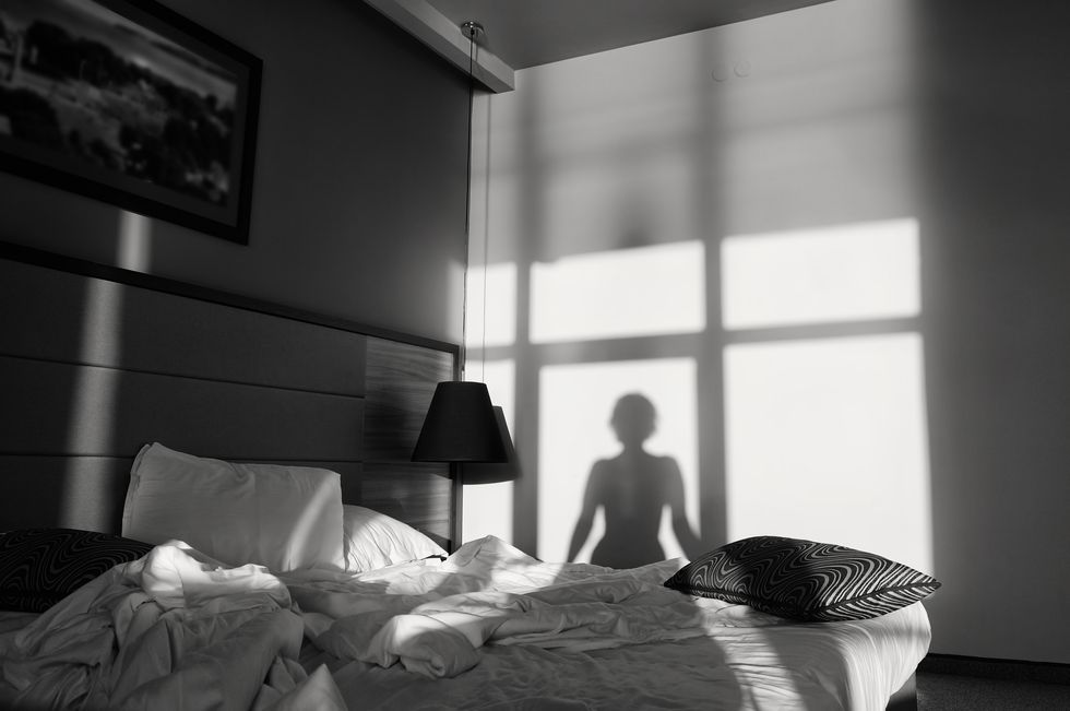 silhouette of a girl in front of a window, black and white art photography monochrome