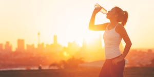 silhouette of a woman drinking form a cold water bottle