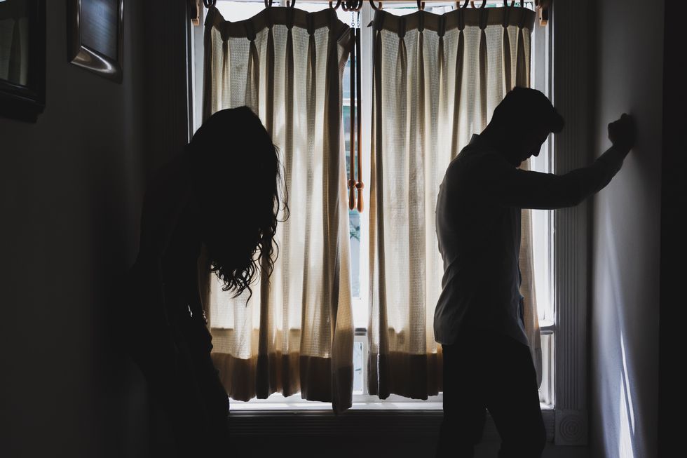 silhouette of a young mexican couple against a window