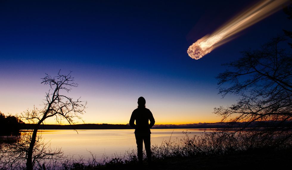 un hombre viendo como un meteorito está a punto de impactar con la tierra