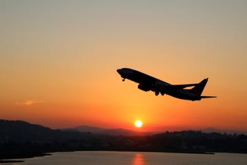 Silhouette of an airplane just after take off during sunset