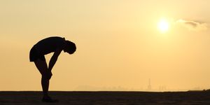 silhouette of an exhausted sportsman at sunset