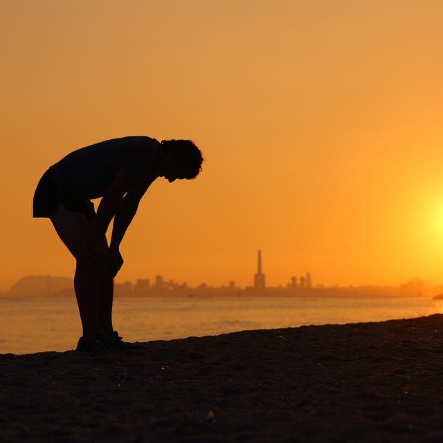silhouette of an tired sportsman at sunset