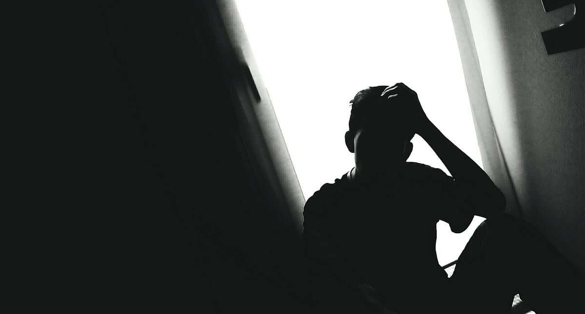 silhouette of disappointed man with his head in hands