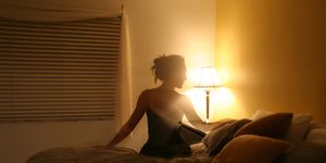 silhouette of woman sitting on bed