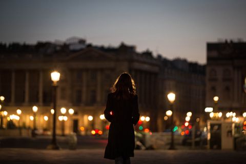 silhouette woman standing on street in city at night