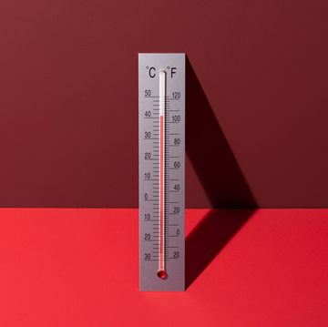 silver thermometer shows high temperature on red background