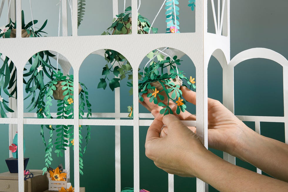 arte en papel de mila garcia, con un invernadero y flores
