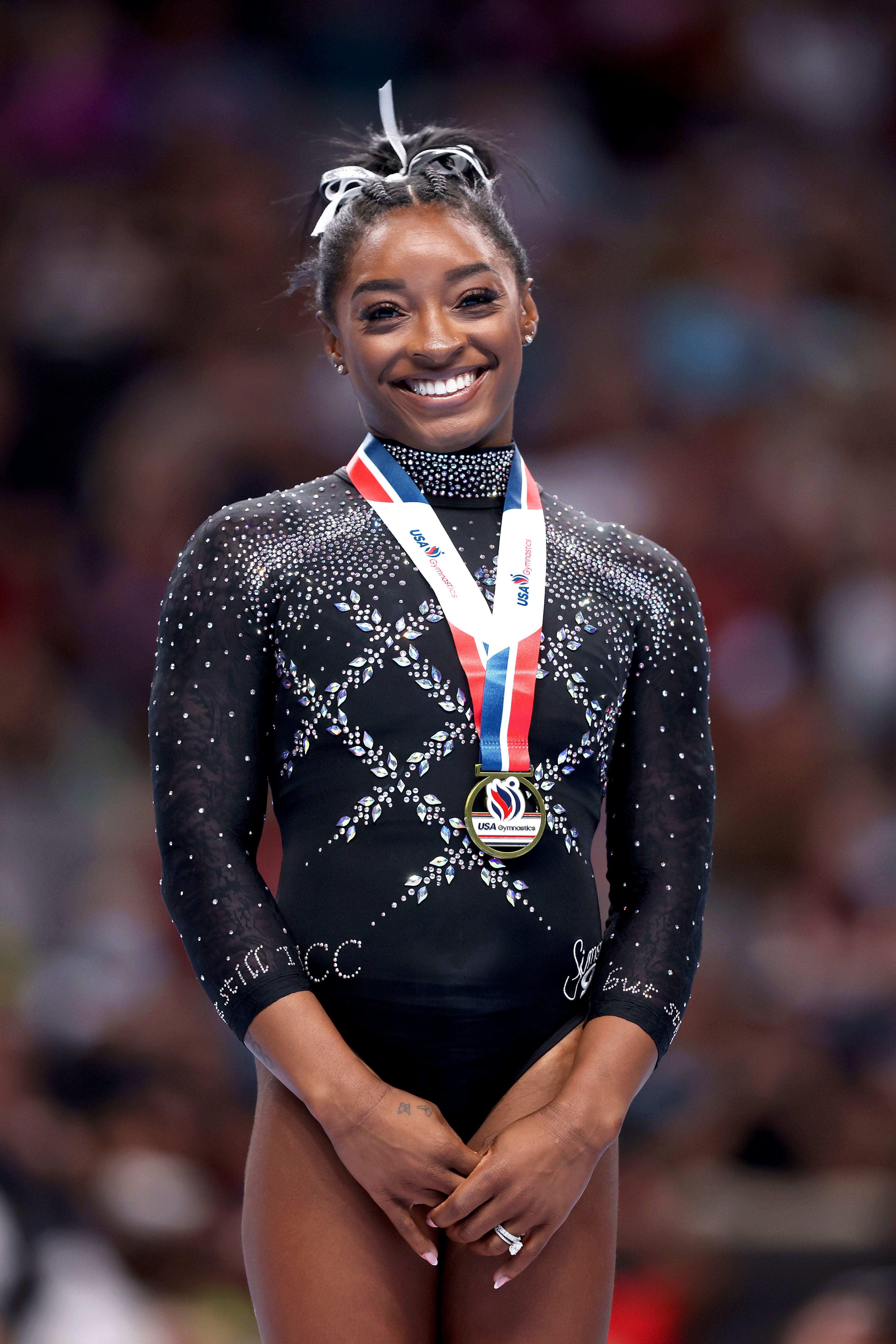 Simone Biles appears on Zoom, flashing her signature million-watt smile. In the arena she has a loaded arsenal, but this smile is what her husband, NFL safety Jonathan Owens, thinks of as her secret weapon. 