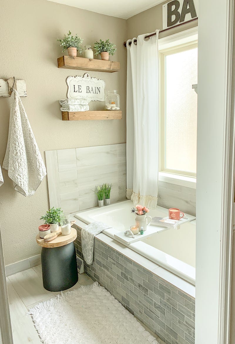 bathroom with wood shelves over tub