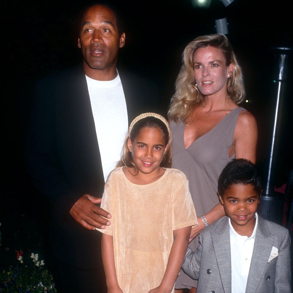 oj simpson, nicole brown simspon, and two kids stand together for a photo