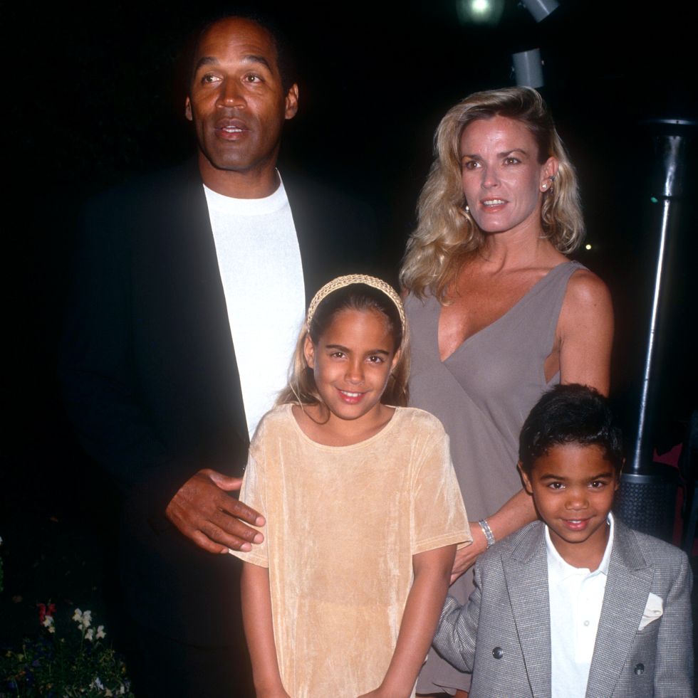 oj simpson, nicole brown simspon, and two kids stand together for a photo
