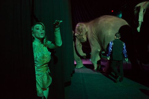 Circusartieste Tatjana Tsjalabajeva werpt een kus naar het publiek terwijl een olifant de arena van Ringling betreedt  gevolgd door een trainer met een bullhook
