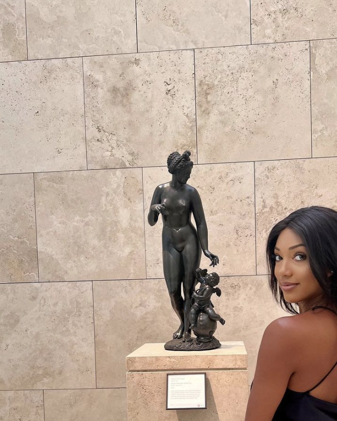 a person posing next to a statue