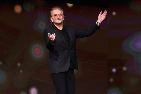 bono of u2 waving to a crowd at a movie premiere