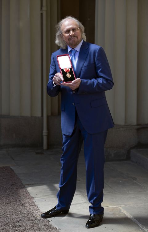 barry gibb holding his medal of knighthood