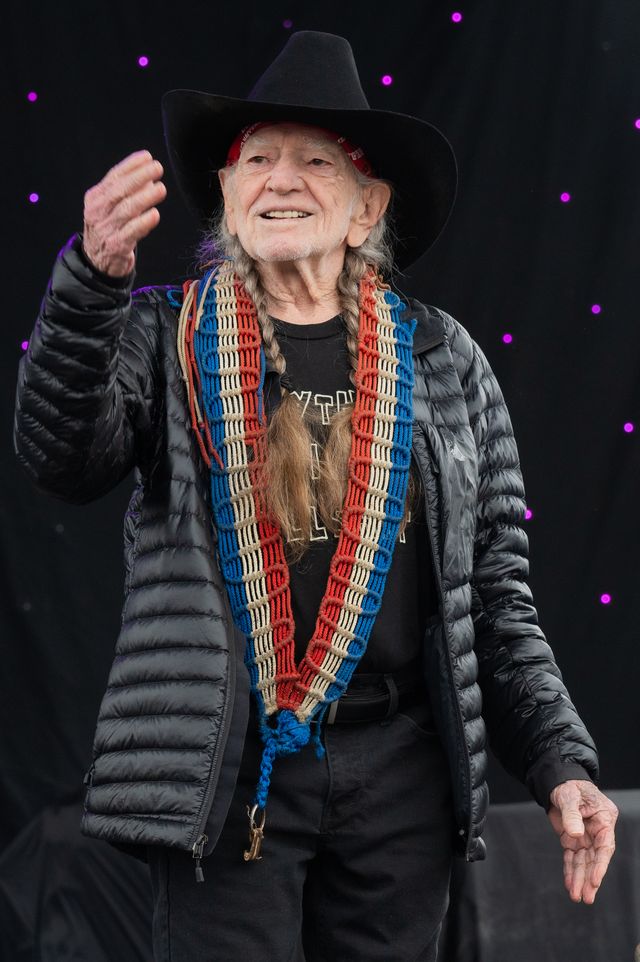 willie nelson waving to the crowd during a performance