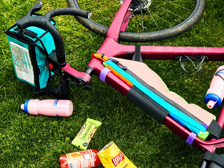 allied bike on grass with water bottle, snacks, bike bags, map