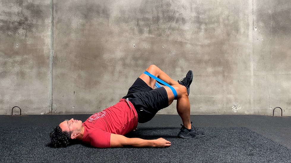 man performing banded single leg glute bridge exercise
