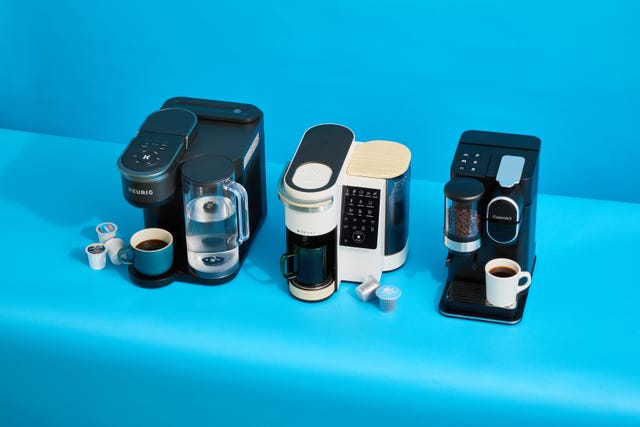 three single serve coffee makers on a blue background