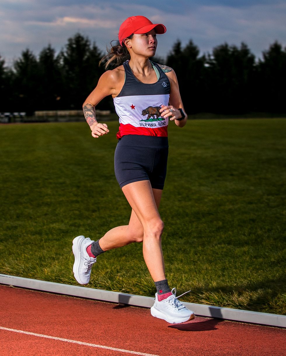 a person running on a track in a california flag singlet