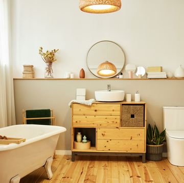 sink with toiletries kept on cabinet by bathtub