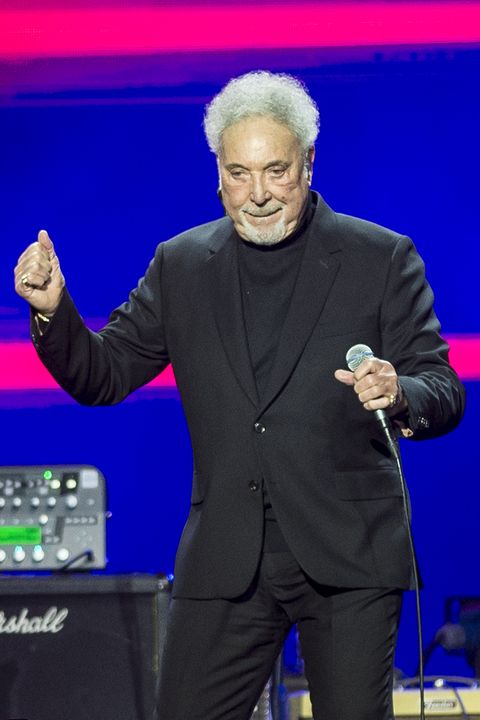 tom jones dancing while holding a microphone