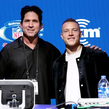 ed mccaffrey and christian mccaffrey standing together and smiling for a photo at super bowl media day