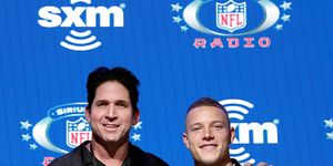 ed mccaffrey and christian mccaffrey standing together and smiling for a photo at super bowl media day