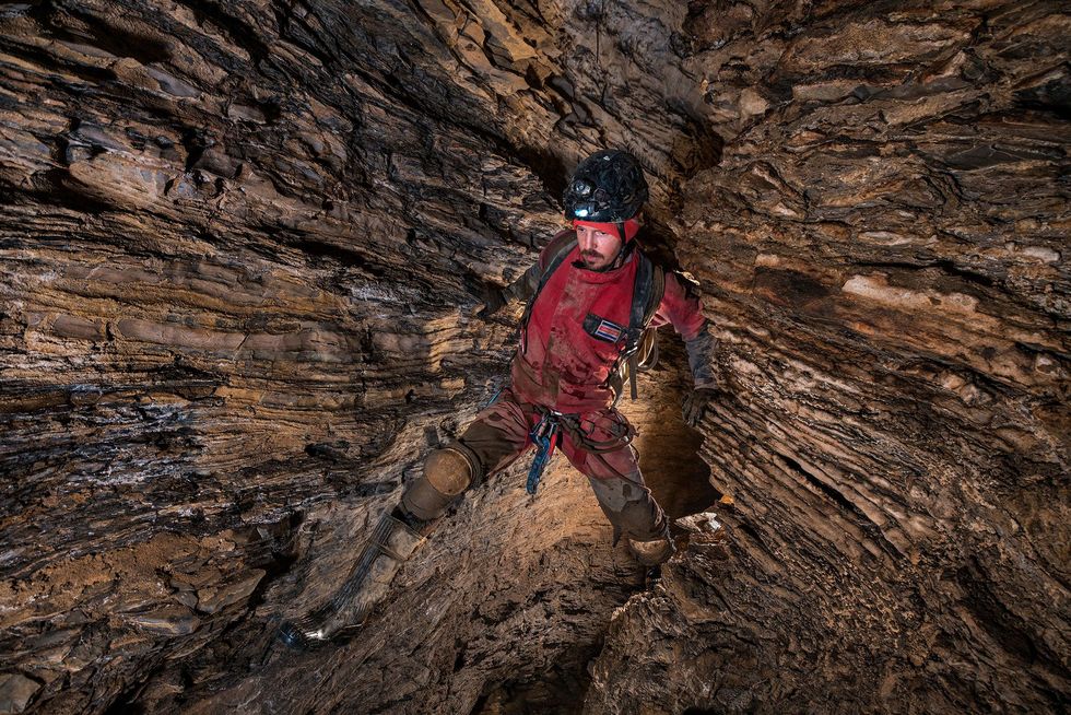Scott Trescott uit Costa Rica klimt over afgebrokkelde rotsblokken terwijl hij zich een weg baant door een canyonpassage in de Stano de Agua de Carrizo