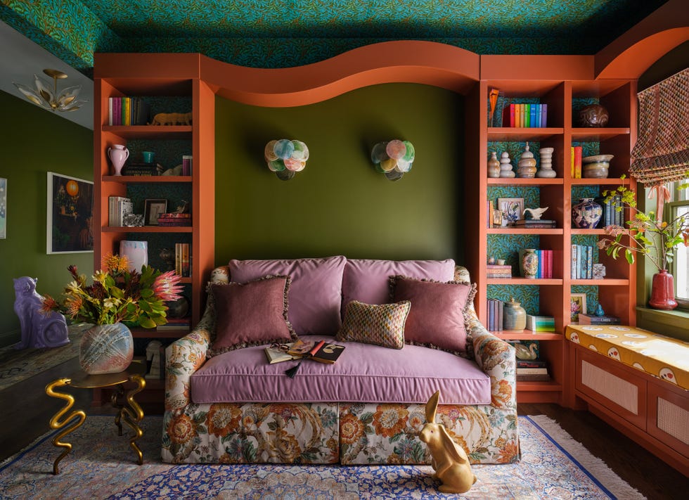 sitting room with green walls and orange bookshelves